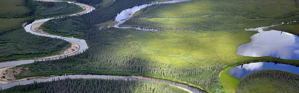 a meandering river flows through a lush green landscape