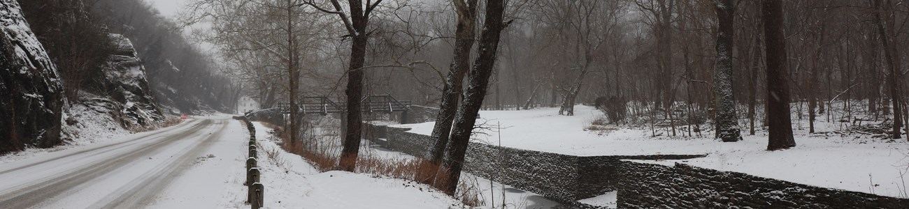 Snow covers the road and nearby canal.