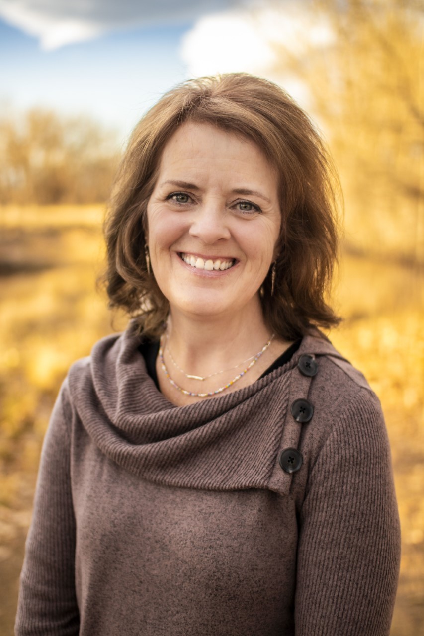 A photo portrait of a woman outside.