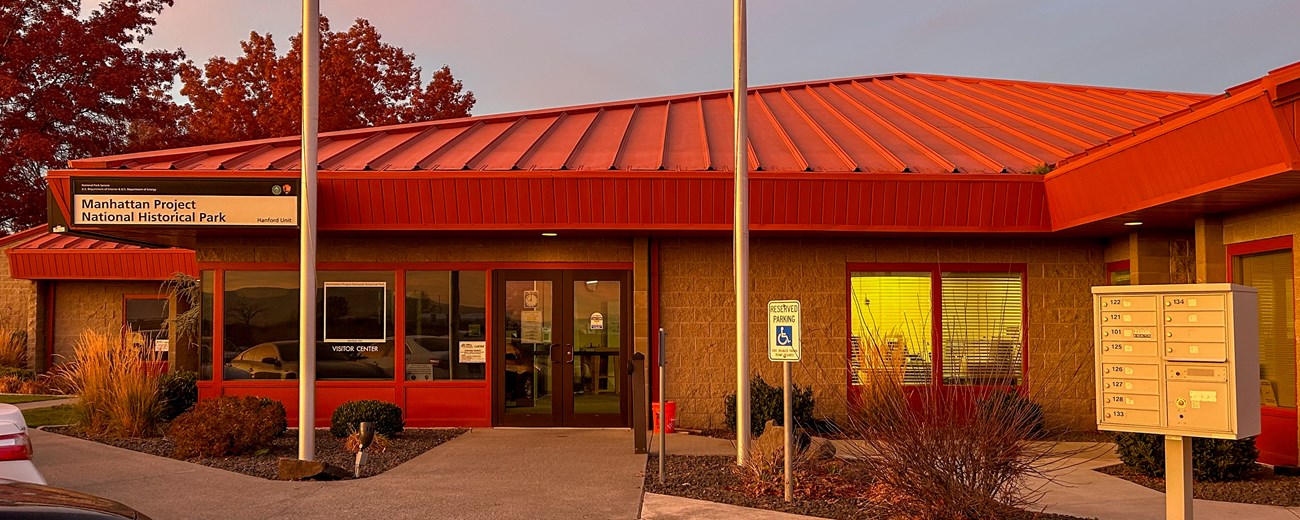 Red-roofed single-level building in warm sunset light - Hanford site Visitor Center