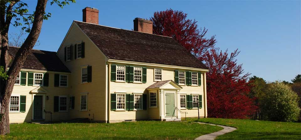 Two story yellow colonial house.