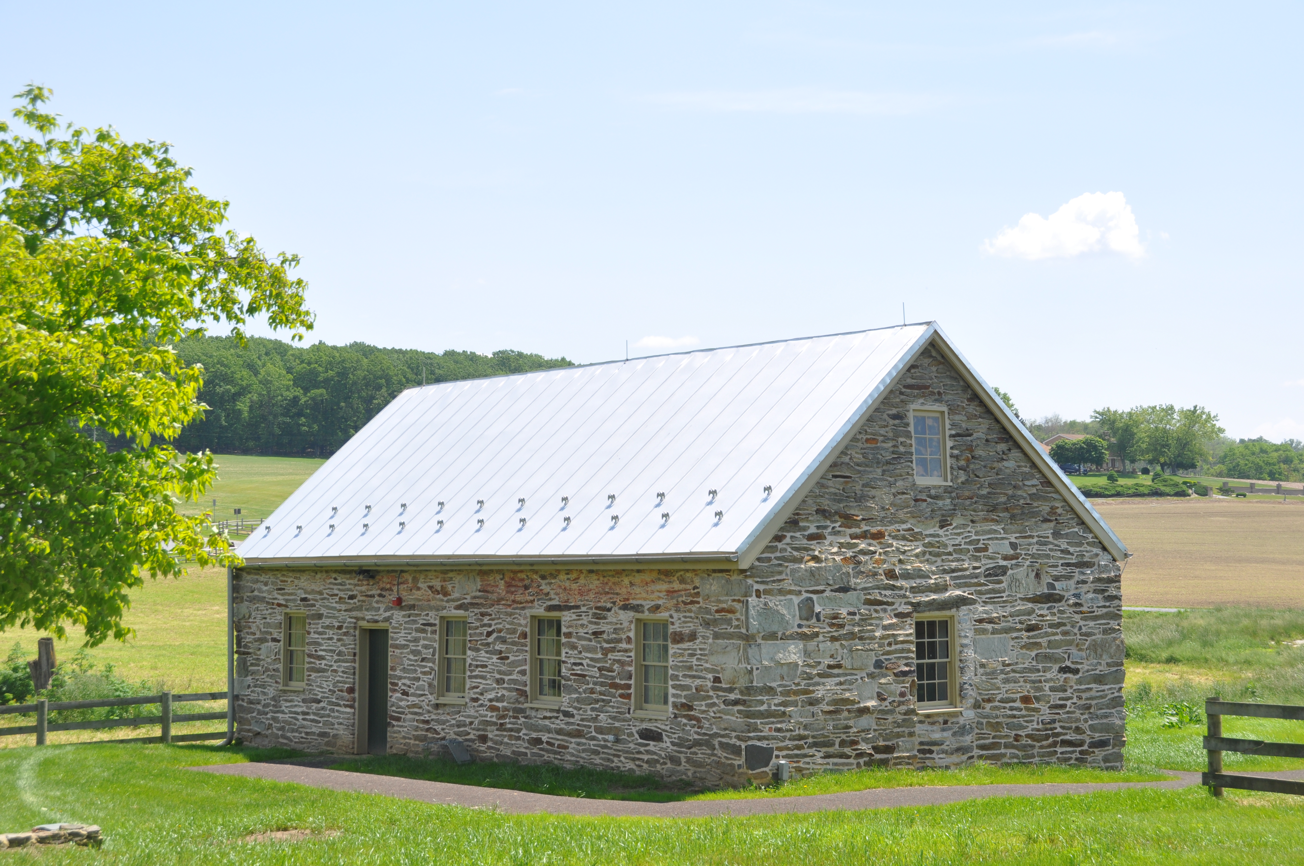 Small single story stone structure with metal roof.