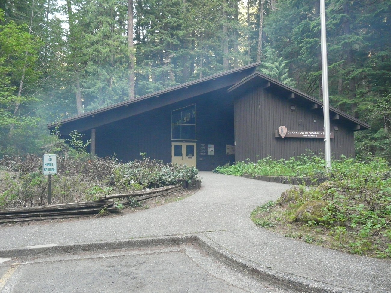 The Ohanapecosh Visitor Center building surrounded by low, heavy smoke clouds.