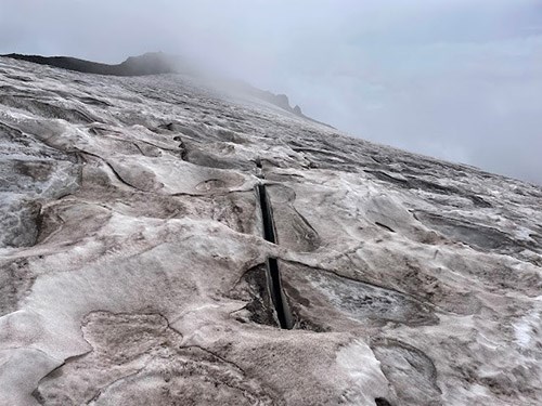 A small crevasse on a snowfield.