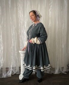 Portrayal of Elizabeth Cady Stanton Theater actress Kim Hanley in a blue-gray period costume portraying American women's rights activist Elizabeth Cady Stanton.