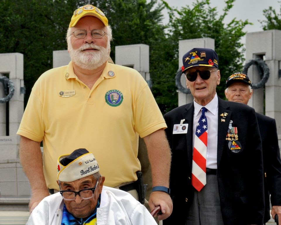 A National Park Service volunteer assists veterans at the World War II Memorial