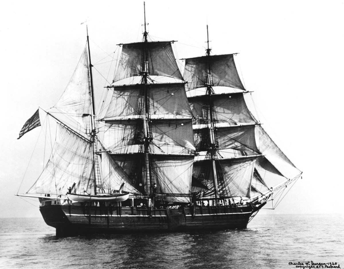 Black-and-white image of Charles W. Morgan, a wooden whaleship, on the ocean.