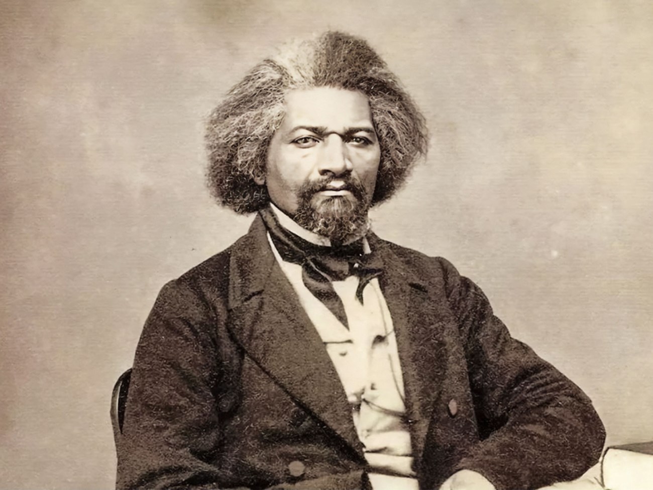 Frederick Douglass FY25 Abolitionist Frederick Douglass sits at a table in 1863.