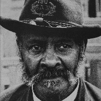 Black and white image of Isaiah King wearing a hat.