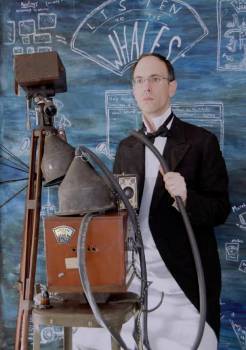 man standing next to strange looking, old contraption