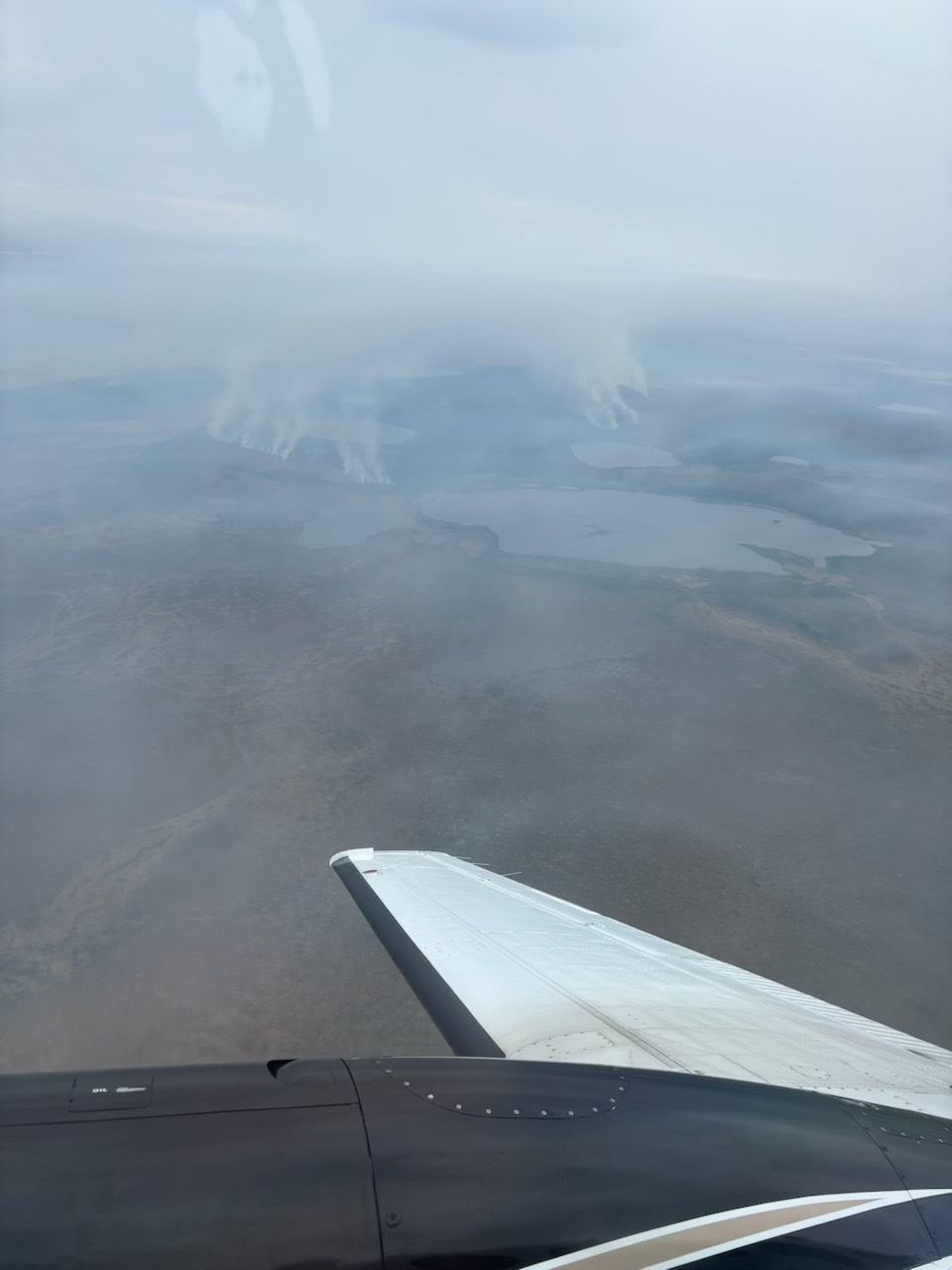 Hazy image from wildfire smoke. Smoke rising from the tundra below a spotter airplane.