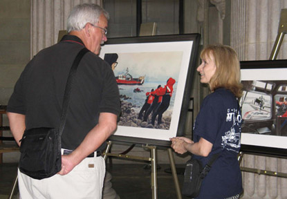 Artist Karen Lowe speaks with a visitor about the Coast Guard art program.