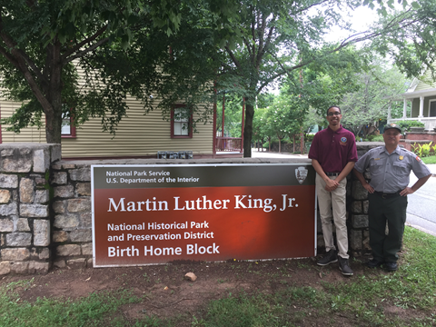 Two people standing next to a sign that reads "Martin Luther King Jr."