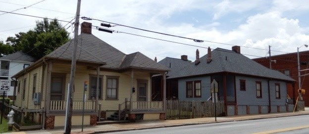 One brown house and one blue house next to a power line