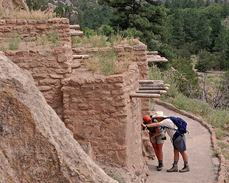 Two visitors peering inside a Pueblo structure