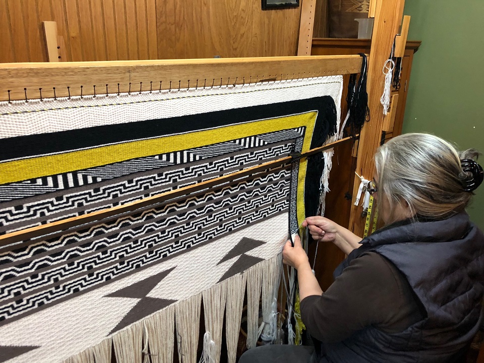 Woman weaving a Generations Robe
