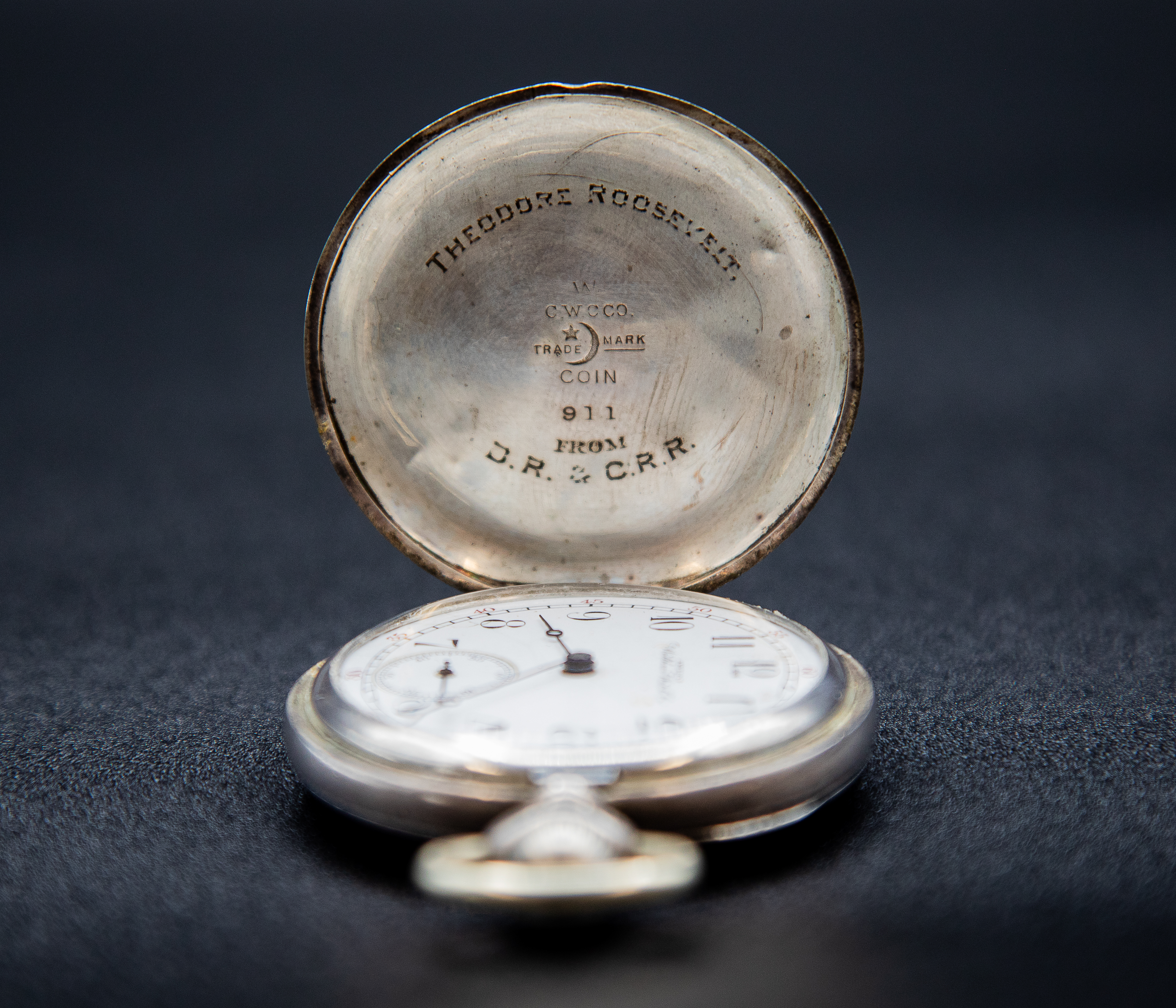 An open pocketwatch against a black background; the words inscribed on the back cover read, "Theodore Roosevelt, From D.R. & C.R.R."