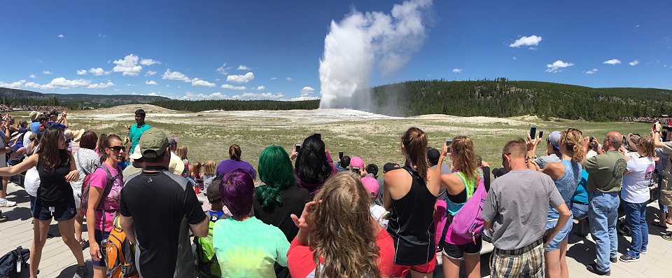 Group of visitors watching a geyser erupt
