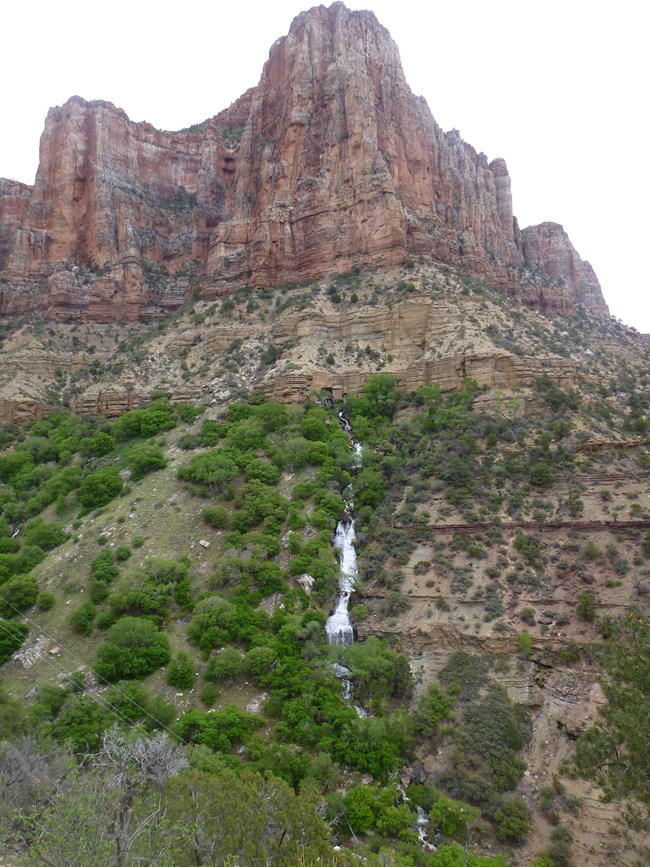 A large rock formation with a waterfall.