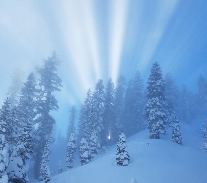 Sunbeams light the sky above a snow-covered slope in Lassen Volcanic National Park. NPS photo by M Matiasek.