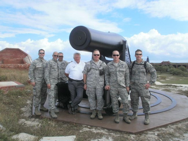 Retirees and active-duty reservists standing in front of a 25-ton Rodman gun