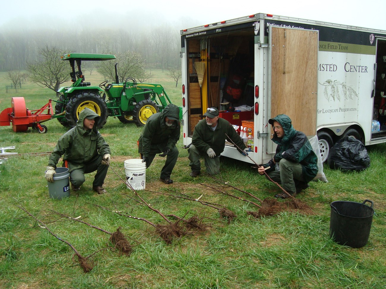 Four maintenance staff in rain gear ...