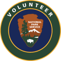 National Park Service arrowhead logo on blue background surrounded by green circle with white text, saying 