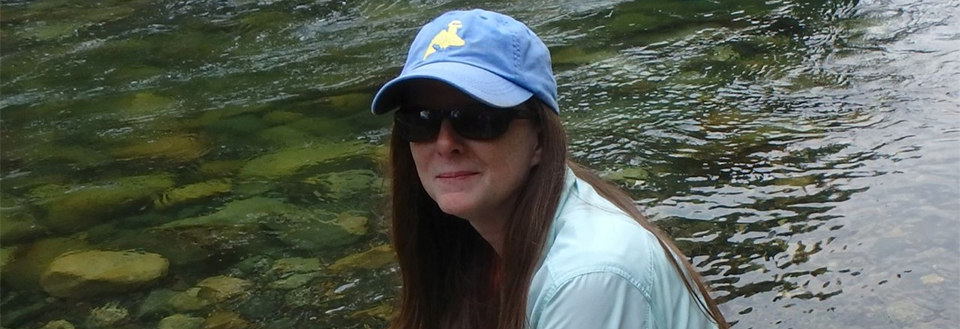 Susan McClendon sitting near a waterway.