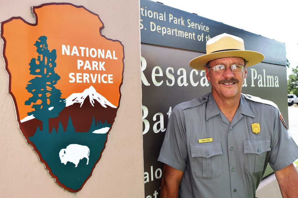 Superintendent Mark Spier stands in front of sign for the Resaca de la Palma Battlefield unit.