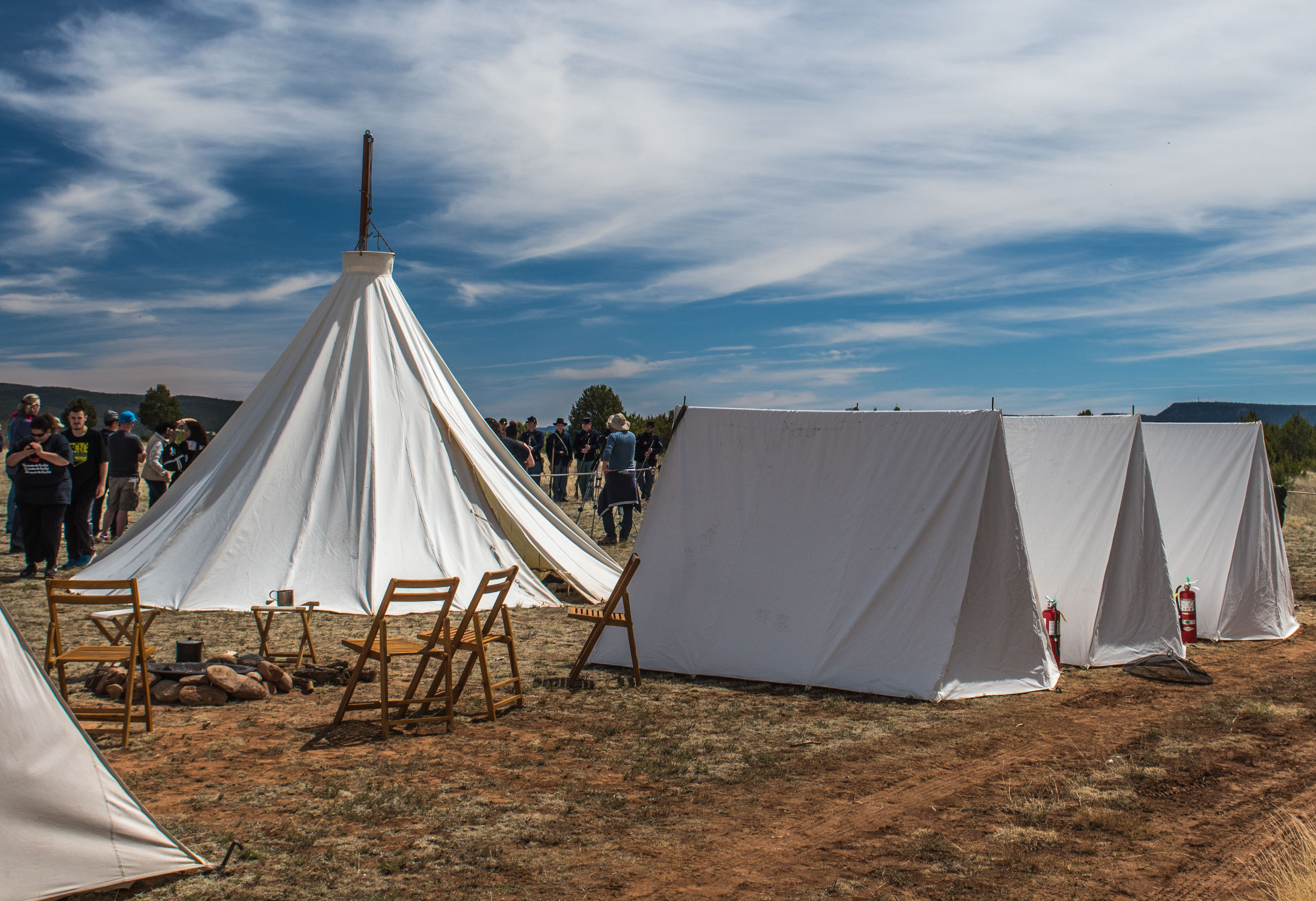 White tents on a dirt and grass field at the Civil War Encampment.