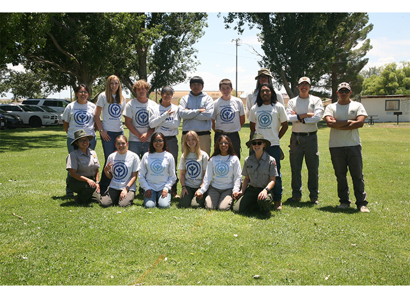 YCC Members 2024, group of people standing in a green park with grass and trees.