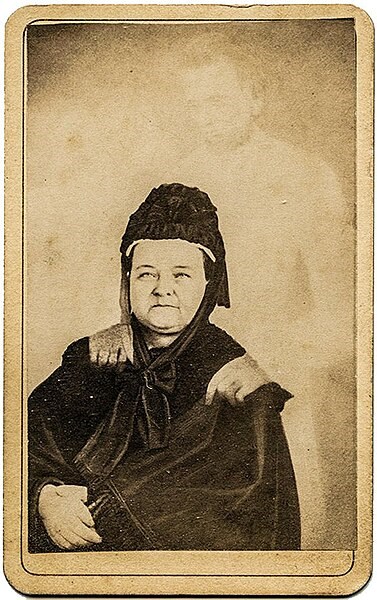 William Mumler's "spirit photograph" of Mary Lincoln Mary Todd Lincoln, wearing a black dress and black bonnet, sits with her hands crossed. A ghostly figure with a beard appears to rest his hands on her shoulders.