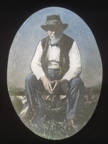 Painted photo of a man, Elijah Nicholas "Uncle Nick" Wilson. A man sitting and wearing a hat.