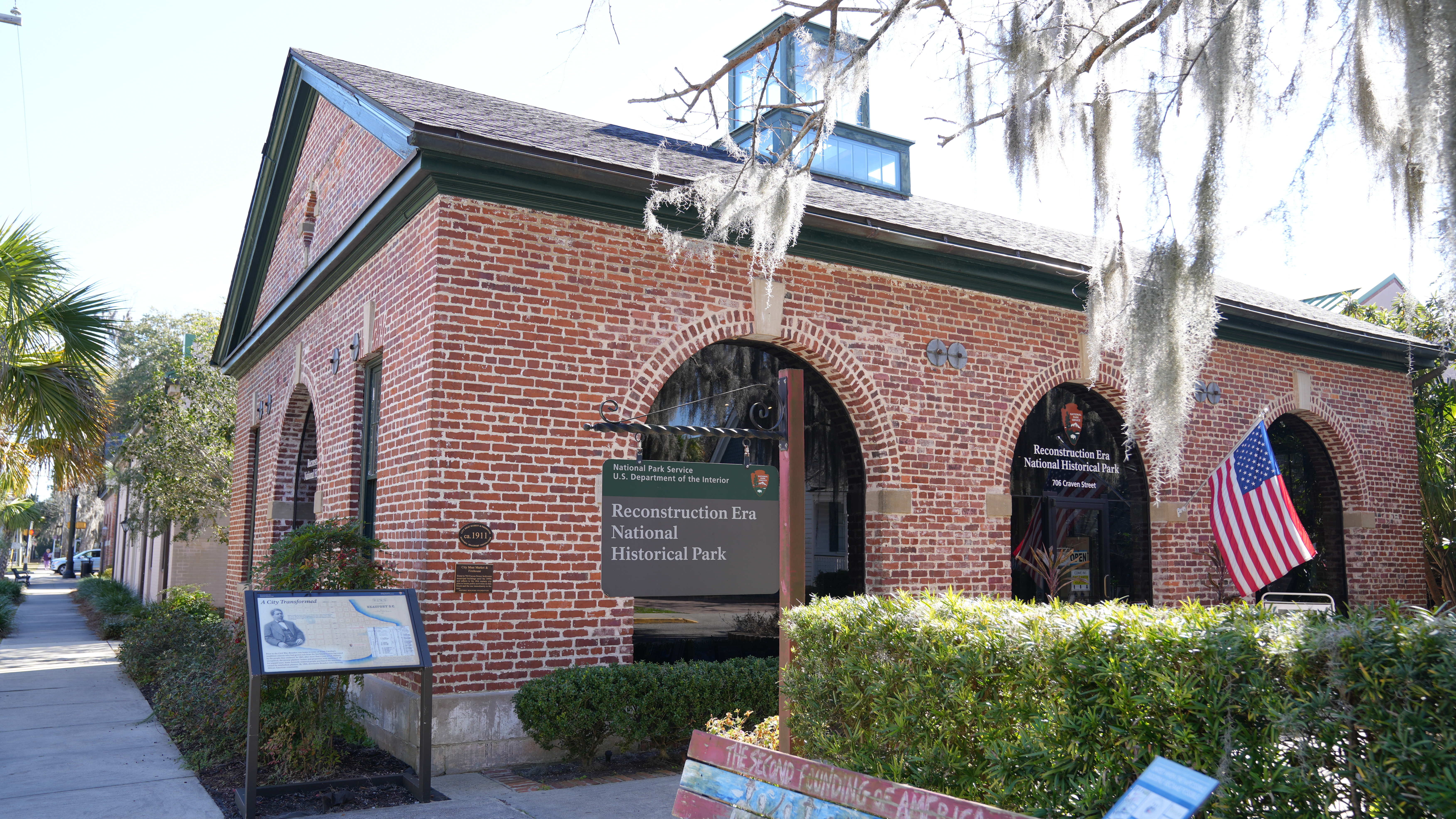 Photograph of the park's visitor center - a one story brick building with high arched windows