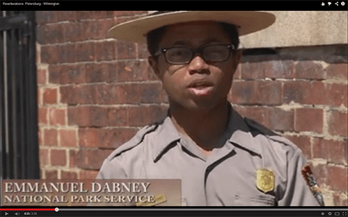 ranger standing in front of a historic brick building