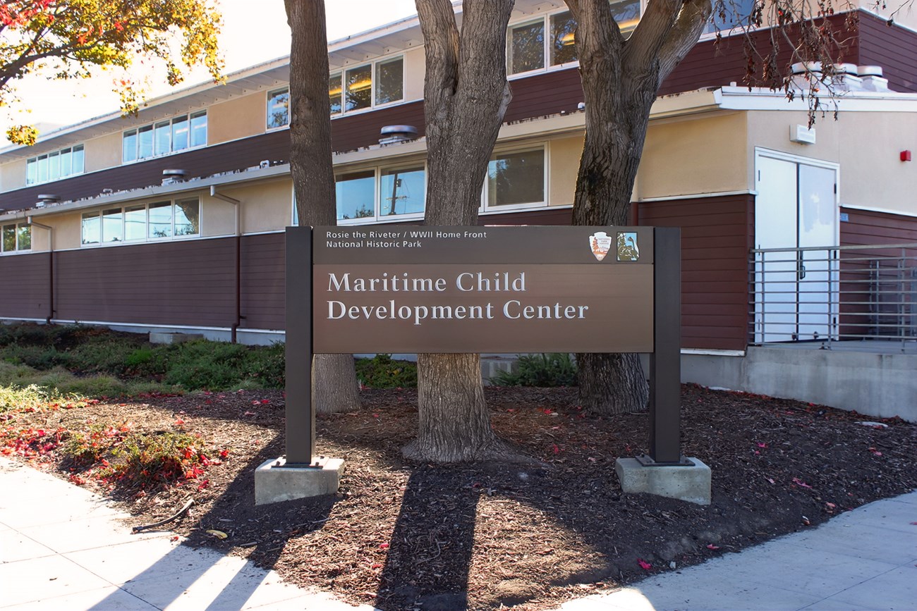 An identity sign with "Maritime Child Development Center" in front of a two-story historic building.