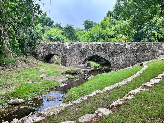 stone Aqueduct with green grass around it