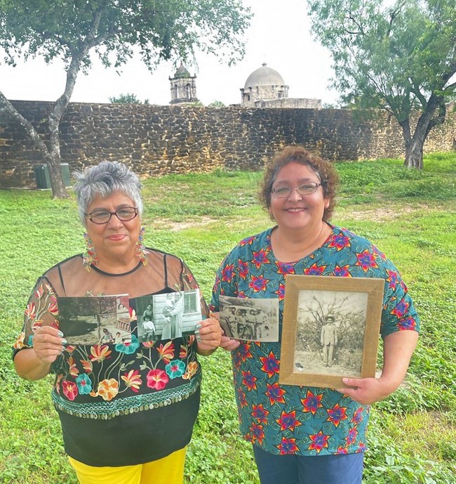 Two sister in holding framed photos.