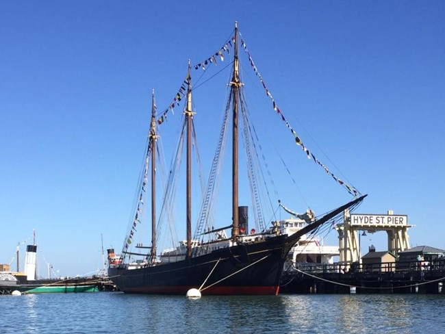 the ship C.A. Thayer is docked to Hyde Street Pier and decorated with flags
