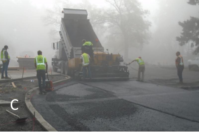 Workers putting down asphalt in front of visitor center