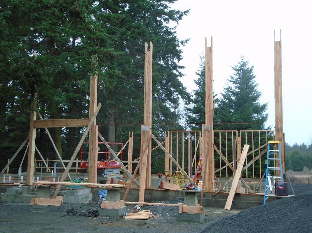 Five stress-rated engineer wood beams are erected on the entry side of the building to help support the rest of the building framing construction