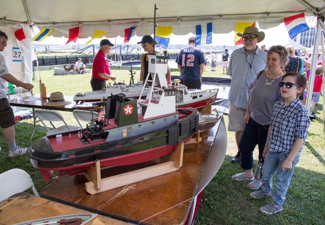 Visitors look at model ships on a table