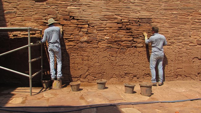 Two park stabilization employees work on the walls of the Abó church ruins