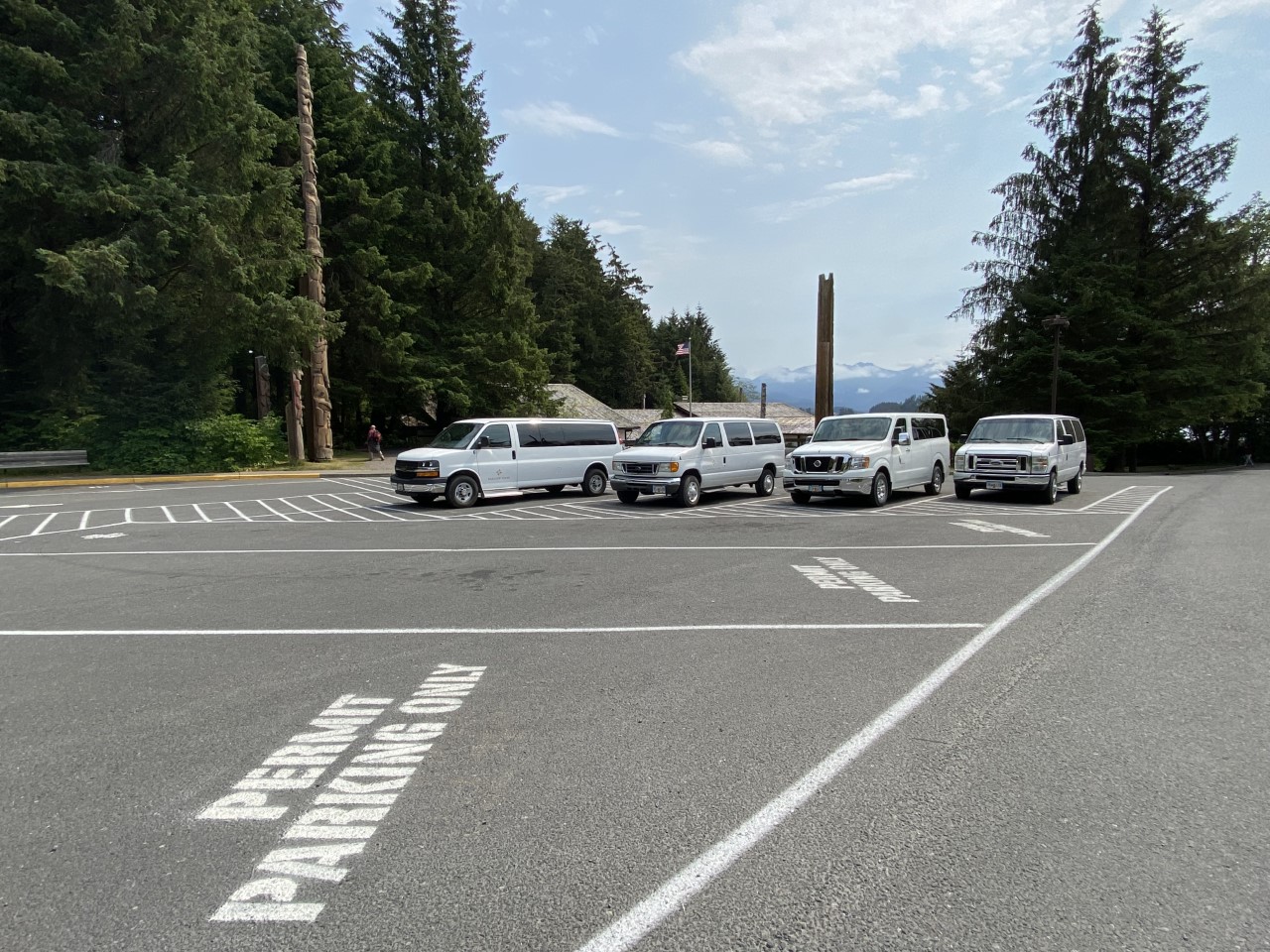 white painted lines stating "permit parking only" and vans parked in the Upper Lot of the Sitka NHP visitor center