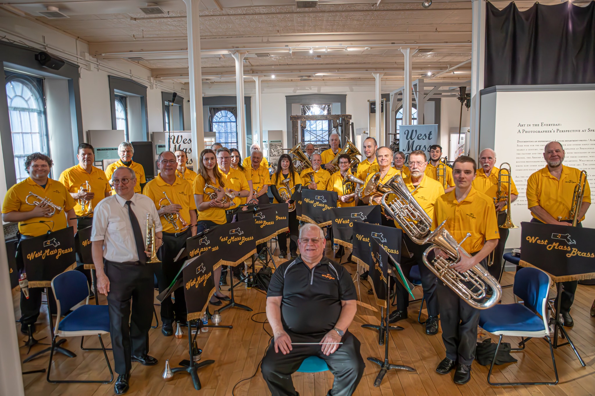 A brass band poses inside a museum.