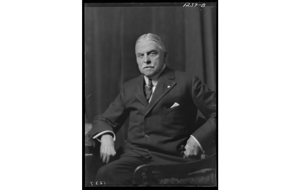 William Truesdale posing seated in an office chair