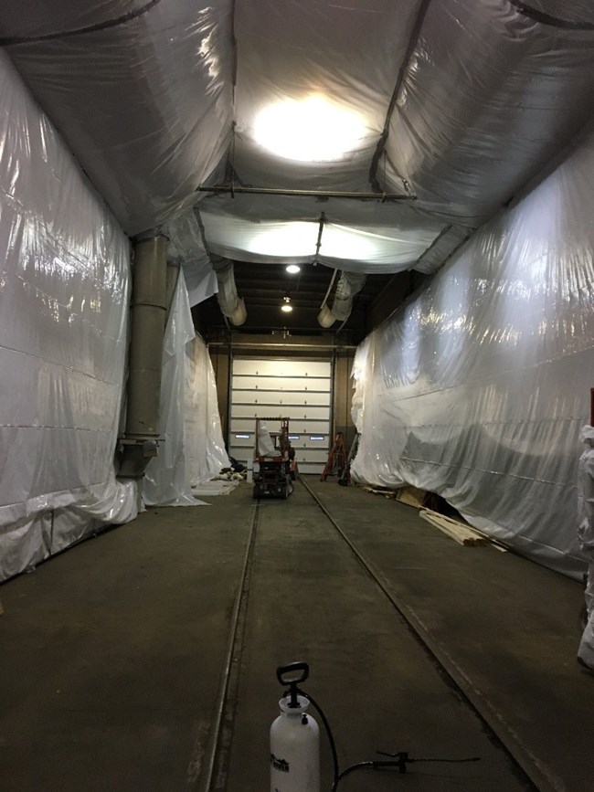 Stall one of our locomotive shop is now an abatement tent, to seal the asbestos in the building while it is removed from the tender. This same space will be used for sand blasting the tender of paint and rust.