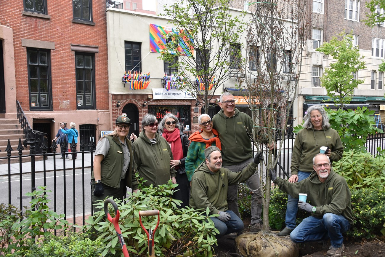 Volunteers gathered around a newly planted Dogwood tree