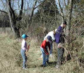 A family of volunteers cutting brush