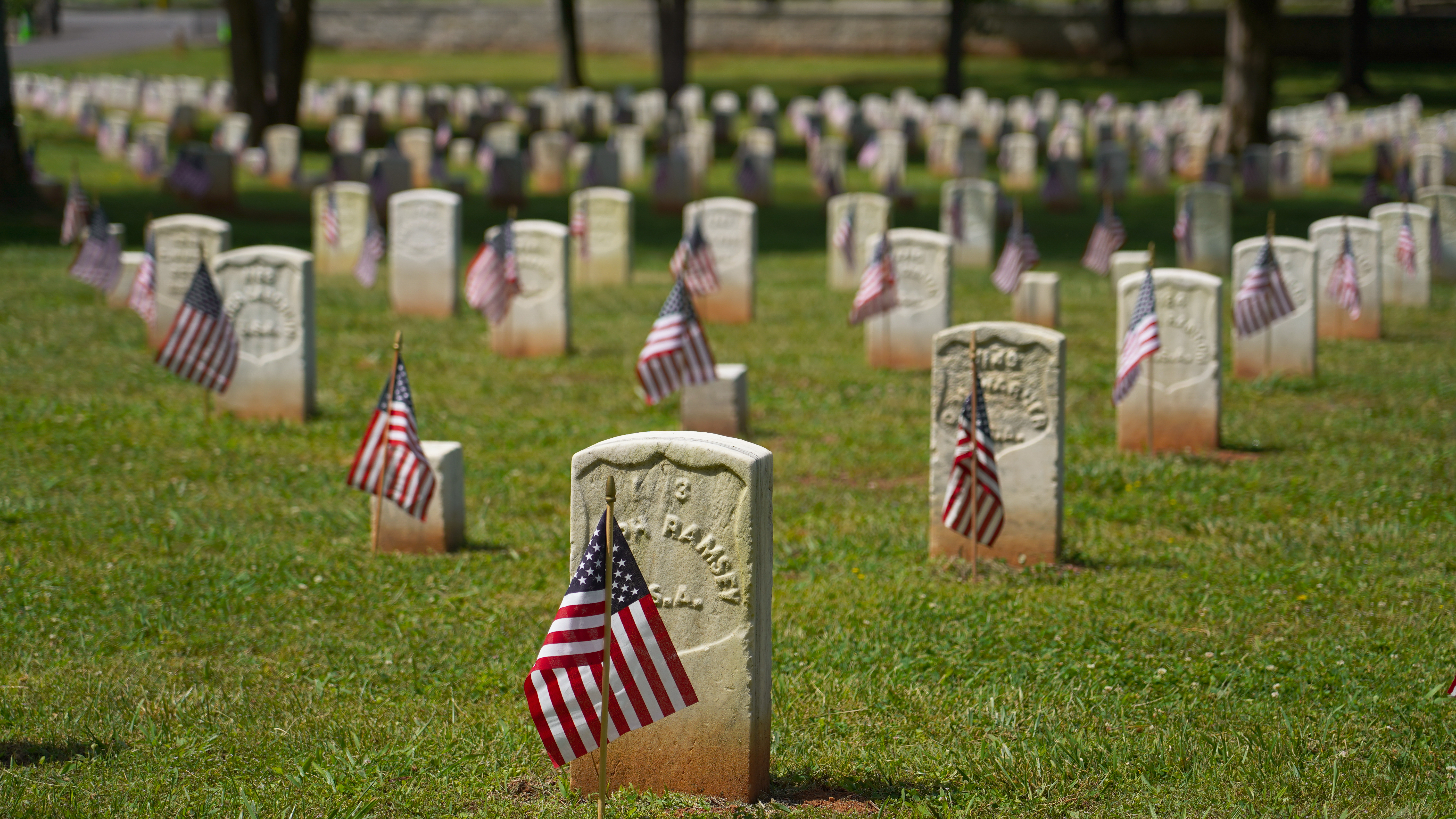 American flags adorn rows of white headstones.